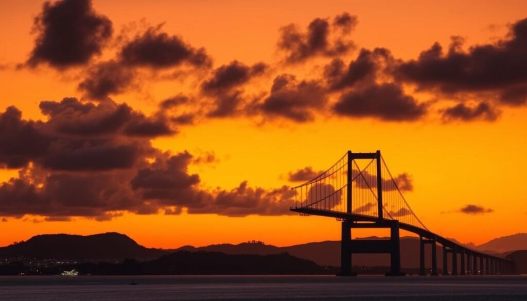 Pôr do sol em Florianópolis com vista para a Ponte Hercílio Luz, símbolo da cidade e seu potencial de crescimento Pôr do sol em Florianópolis com vista para a Ponte Hercílio Luz, símbolo da cidade e seu potencial de crescimento